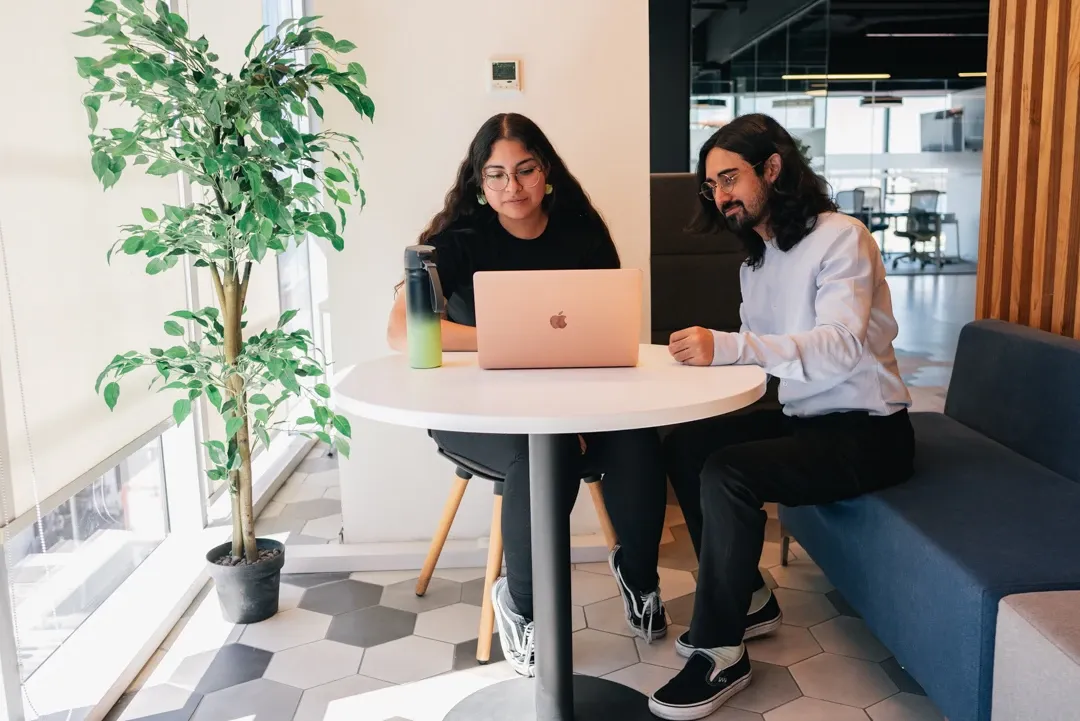 Dos empleados de Costera Group usando un computador